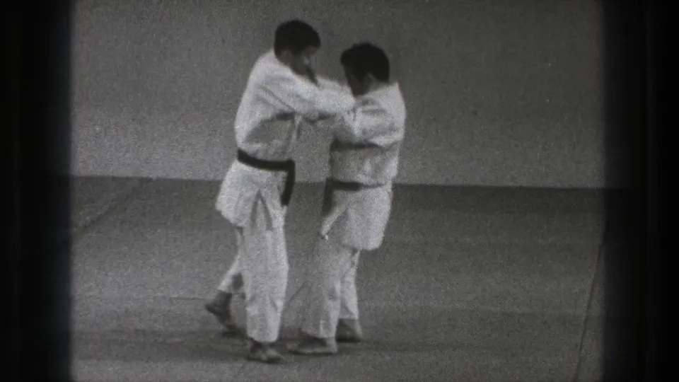 Near the end of the 1971 Tokyo clip, the two practitioners remain in contact while adjusting their stance on the mat.