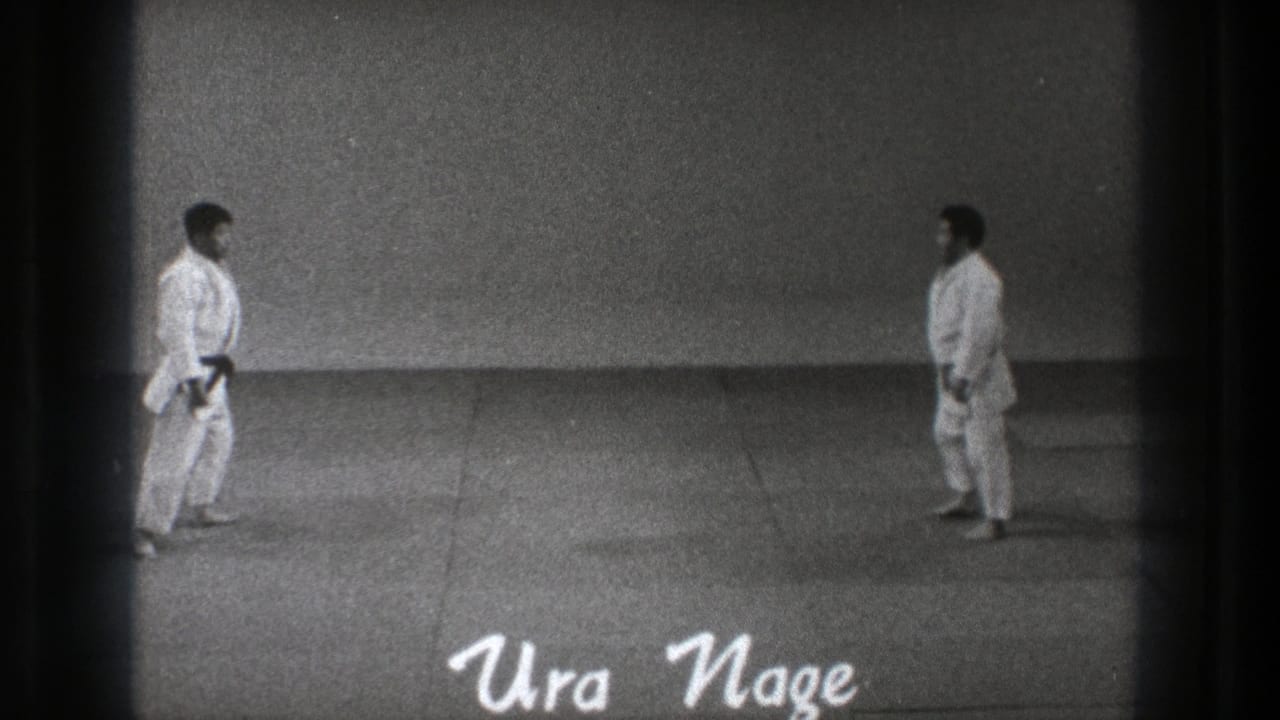 1971 Tokyo 8mm frame with two judo practitioners facing each other across the mat before the Ura Nage demonstration.