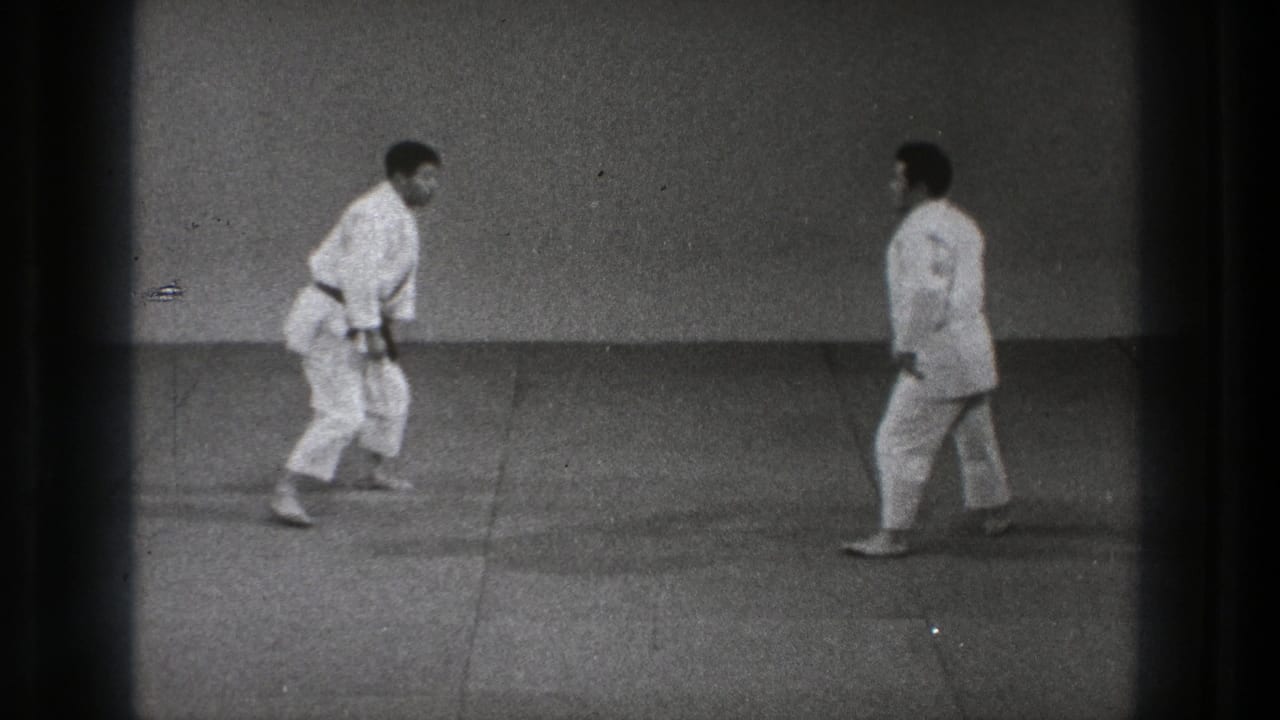 In the final frame, two adult men in white gi and dark belts face each other on the dojo mat in the 1971 Tokyo footage.