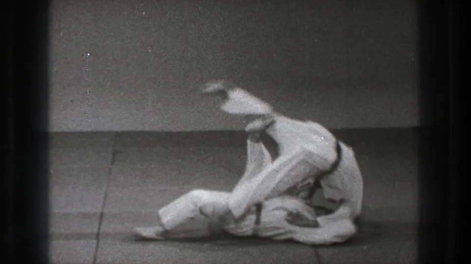 The Tokyo judo practice sequence shows one practitioner in white gi being thrown while the other controls the movement.