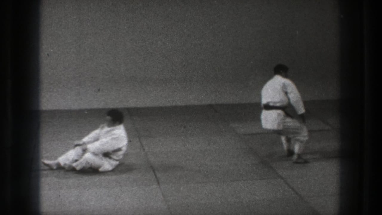 The final frame shows one judo practitioner seated on the tatami while another in a white gi walks away across the dojo.