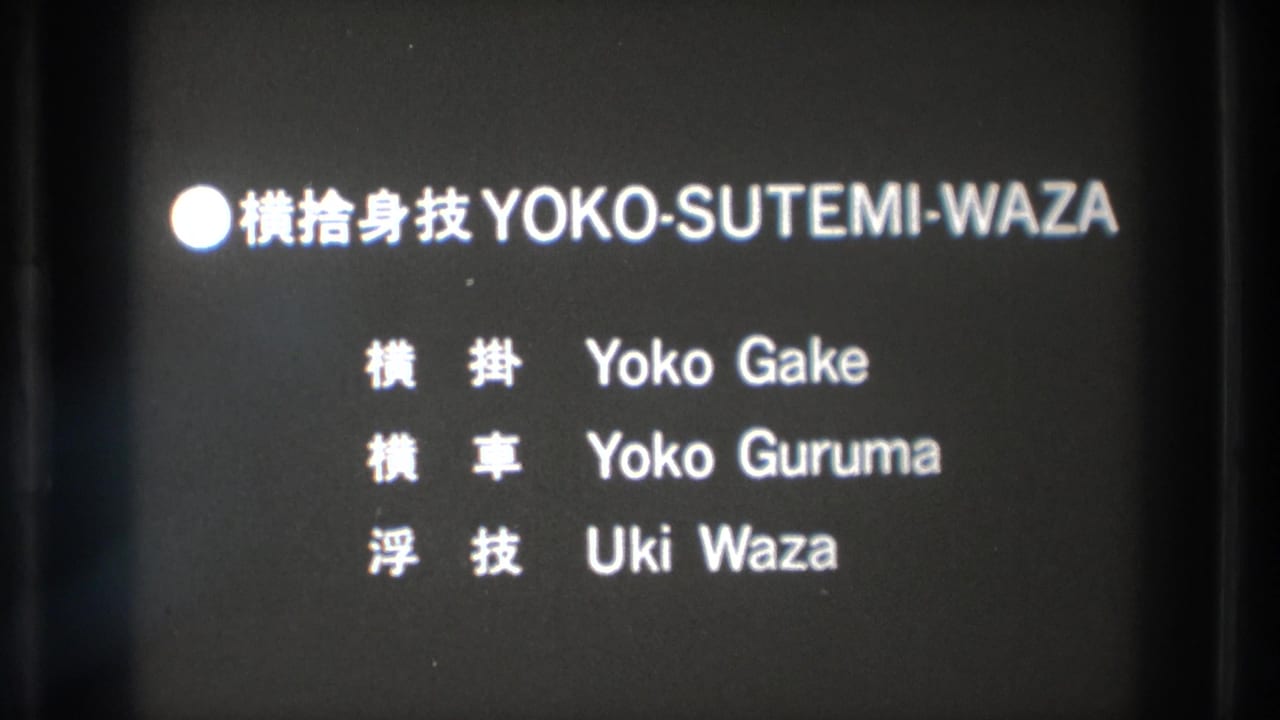 The projected 8mm frame shows a Yoko-Sutemi-Waza title card with Japanese characters and romanized technique names.