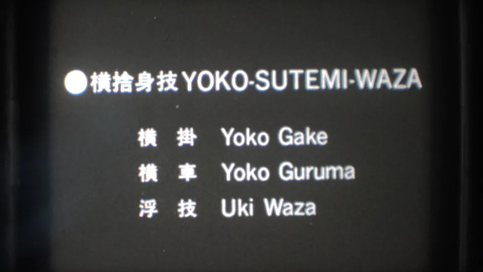 The projected 8mm frame shows a Yoko-Sutemi-Waza title card with Japanese characters and romanized technique names.