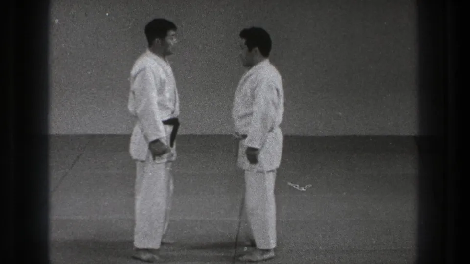 In 1971 Tokyo footage, two adult men in karate gi face each other before beginning a partner technique.