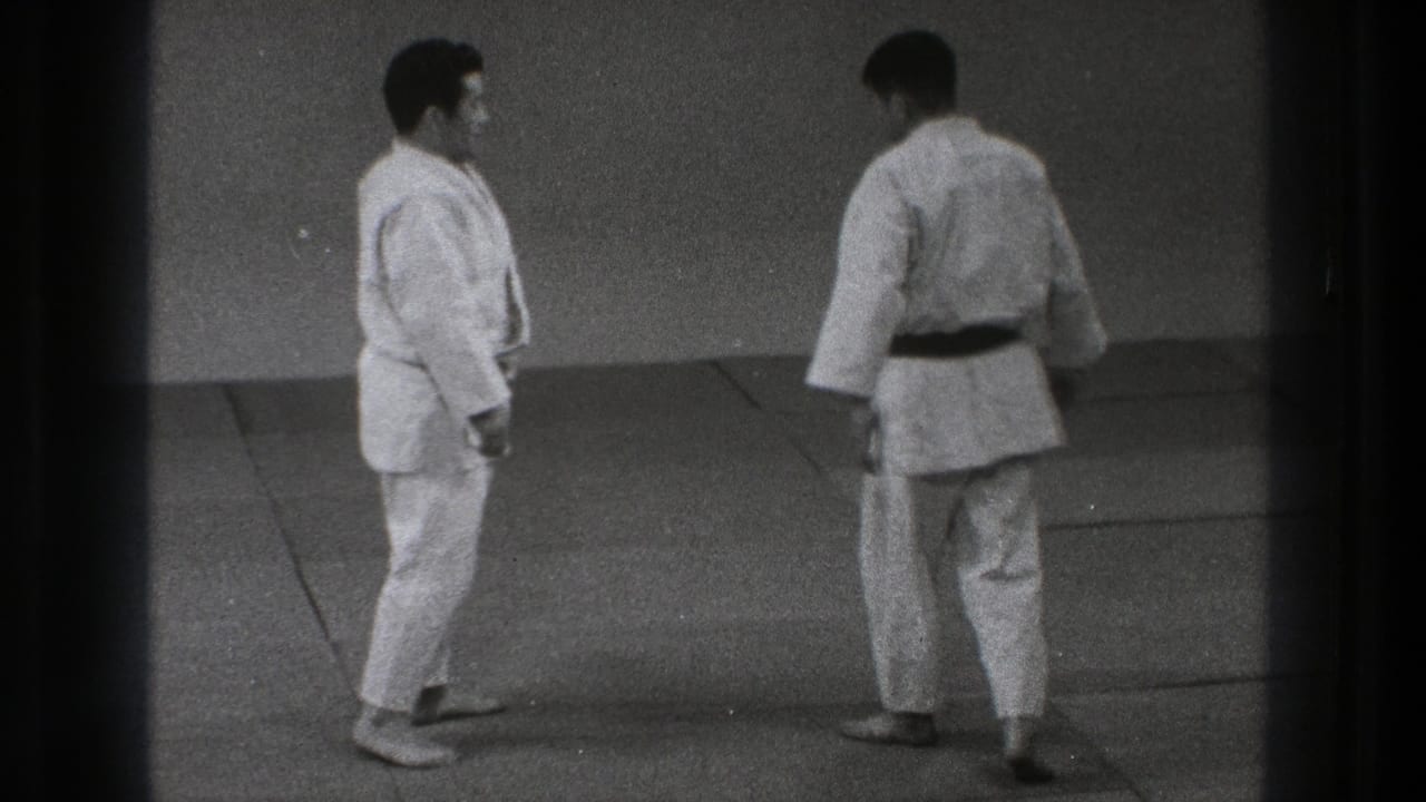 In Tokyo, Japan, 1971, two adult judo practitioners in white gi stand on a mat before beginning a demonstration.
