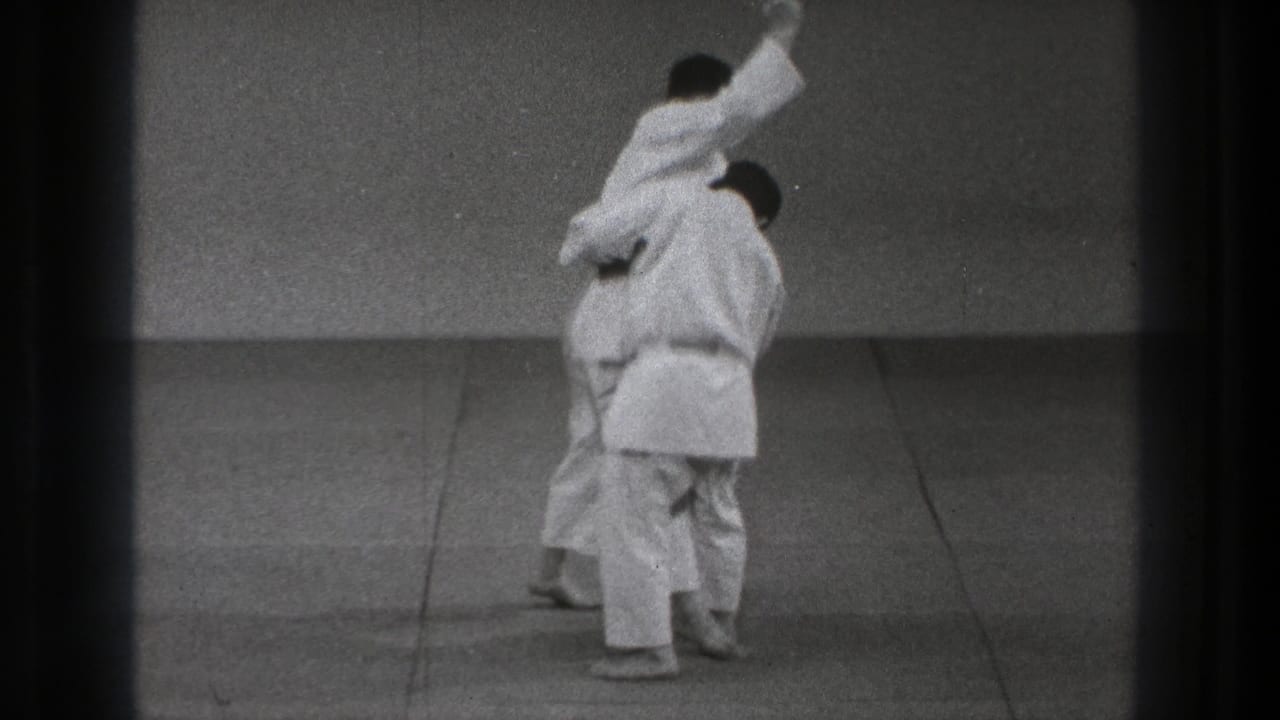 One adult man in a white uniform appears to execute a throwing move on his partner in 1971 Tokyo footage.