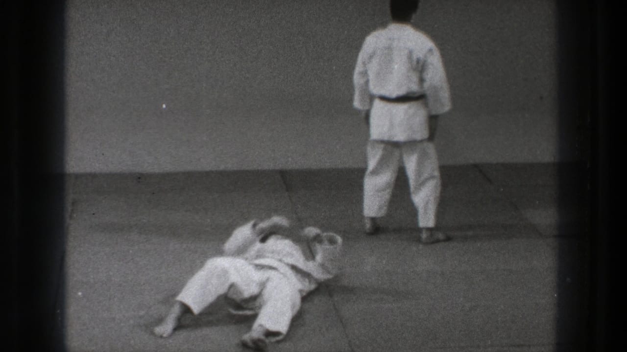 After the throw, one participant lies on his back while another stands facing the wall in the 1971 Tokyo practice footage.