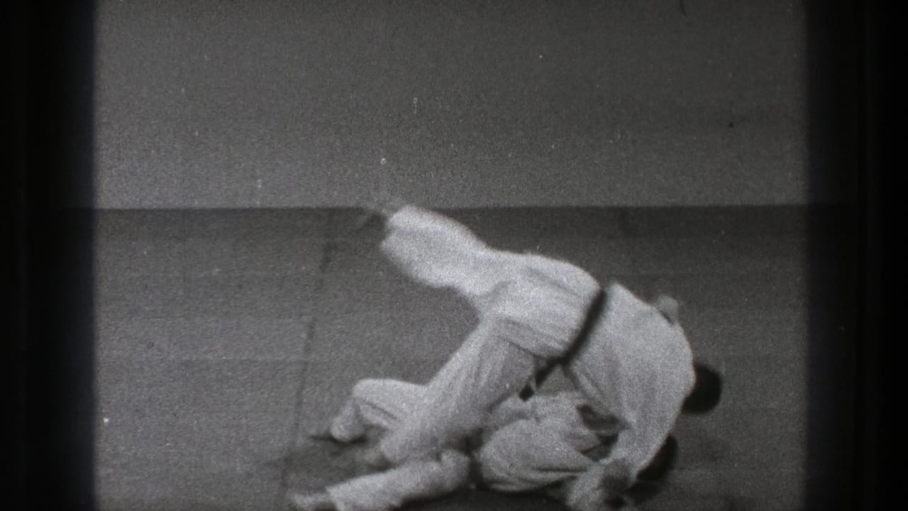 Tokyo 1971 8mm frame showing two martial artists in white gi on a padded mat during a throw.