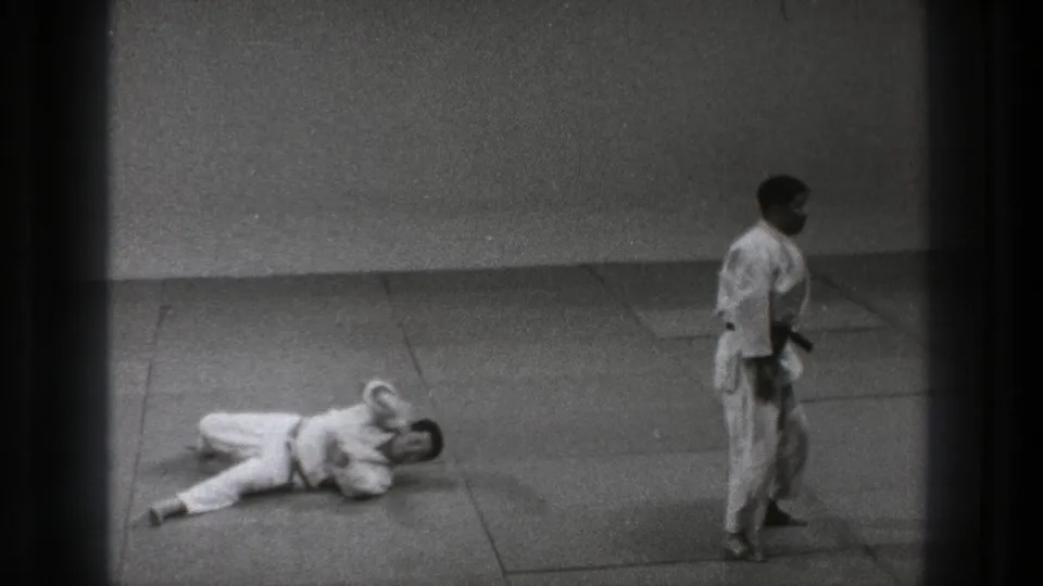 Tokyo 1971 8mm frame with a fallen martial artist on the mat and a standing partner in a white gi.