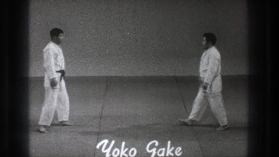 The two adult martial artists move toward the center of the mat in the 1971 Tokyo martial arts clip, with Yoko Gake text partly visible below.