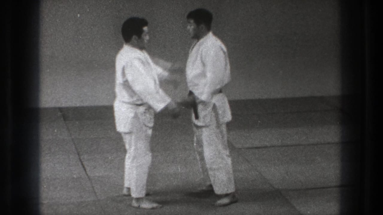 A karate practitioner reaches toward his partner during a controlled 1971 Tokyo self-defense demonstration.