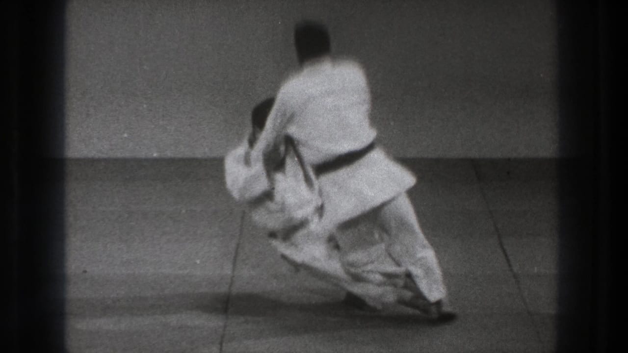 The 1971 Tokyo footage shows a black-belt practitioner executing a judo throw as the partner falls toward the mat.