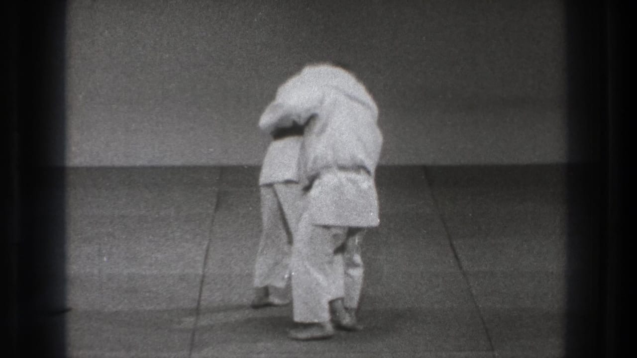 1971 Tokyo 8mm frame showing two martial arts practitioners in close contact during a grappling or throwing sequence.