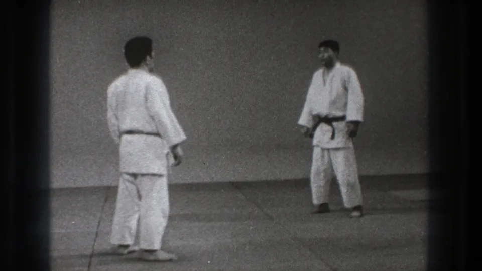 1971 Tokyo 8mm frame of two adult martial artists in gi standing apart before resuming practice.