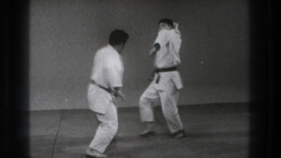 1971 Tokyo 8mm frame showing two martial artists in white gi preparing for another judo-style exchange.