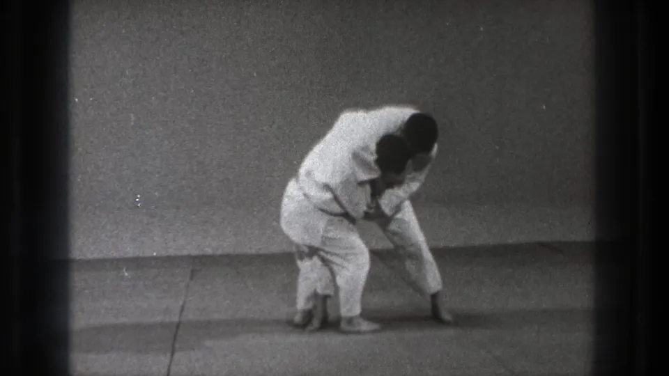 Near the end of the Tokyo 1971 clip, the practitioners stay locked in a compact throw position on the mat.