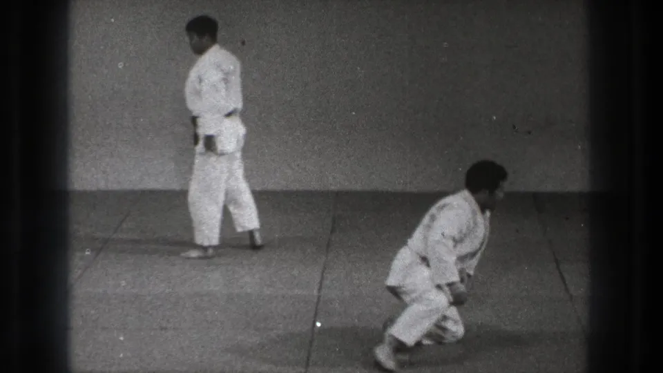 The final frame shows one man standing in a white uniform as another kneels or rises on the mat during 1971 Tokyo martial arts practice.