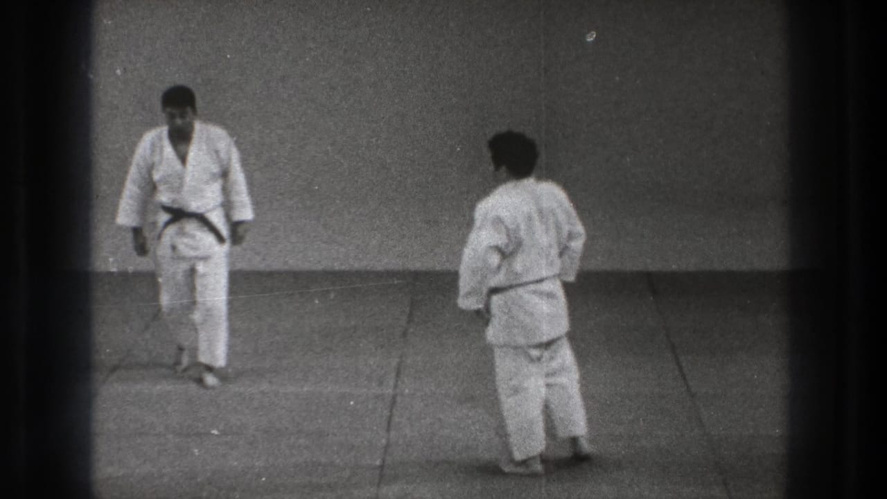 1971 Tokyo dojo practice with two men in white gi facing each other across a plain matted floor.