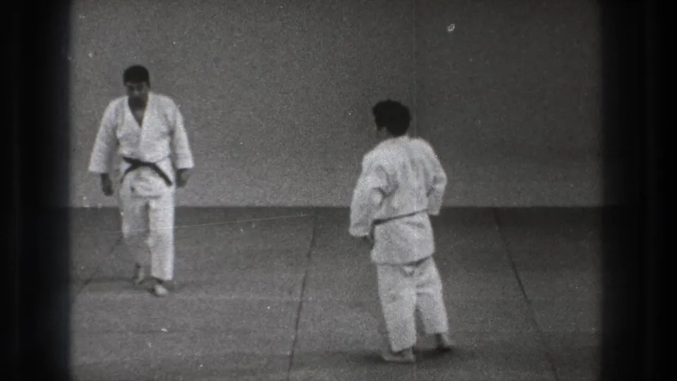 1971 Tokyo dojo practice with two men in white gi facing each other across a plain matted floor.