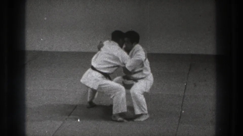 The Uki Waza practice continues with both men crouched low and joined at the upper body in the 1971 Tokyo 8mm footage.