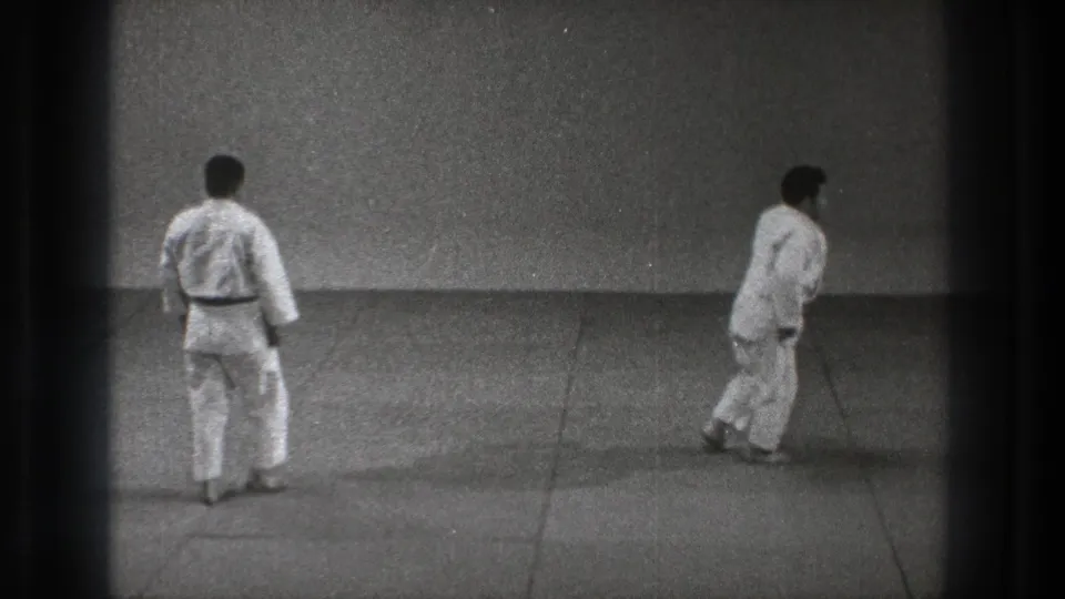 Near the end of the Tokyo 1971 practice clip, both men in white gi are upright on the mat after the throw and recovery movement.