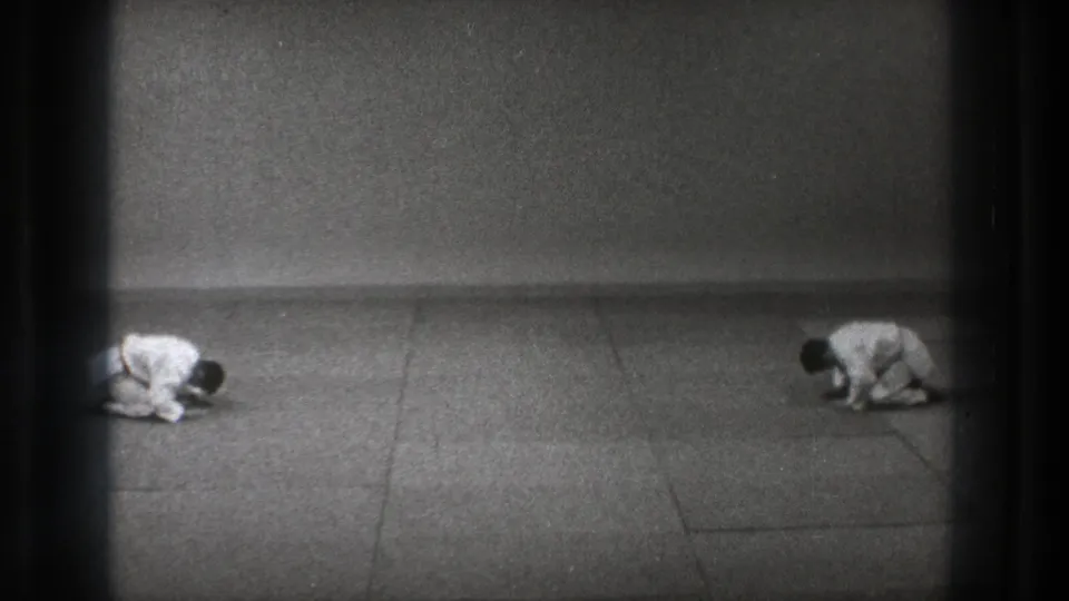 1971 Tokyo dojo footage showing two martial arts practitioners bent forward in a synchronized formal bow.