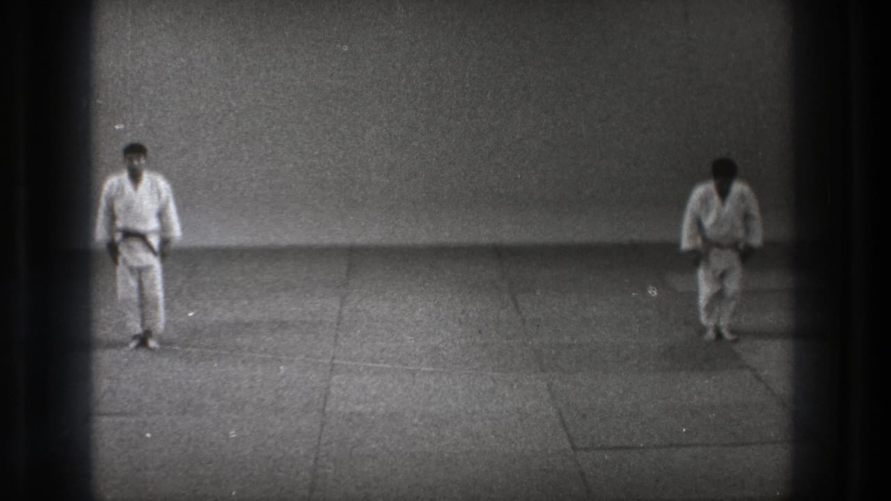 In the closing frame, two men in karate gi stand on the mat as the formal ritual appears to move toward the next action.