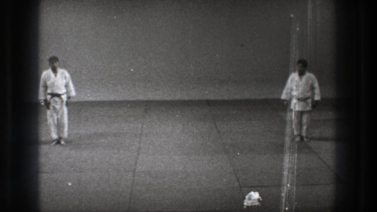 Black-and-white 8mm view from Tokyo 1971 showing two karate practitioners standing apart after bowing.