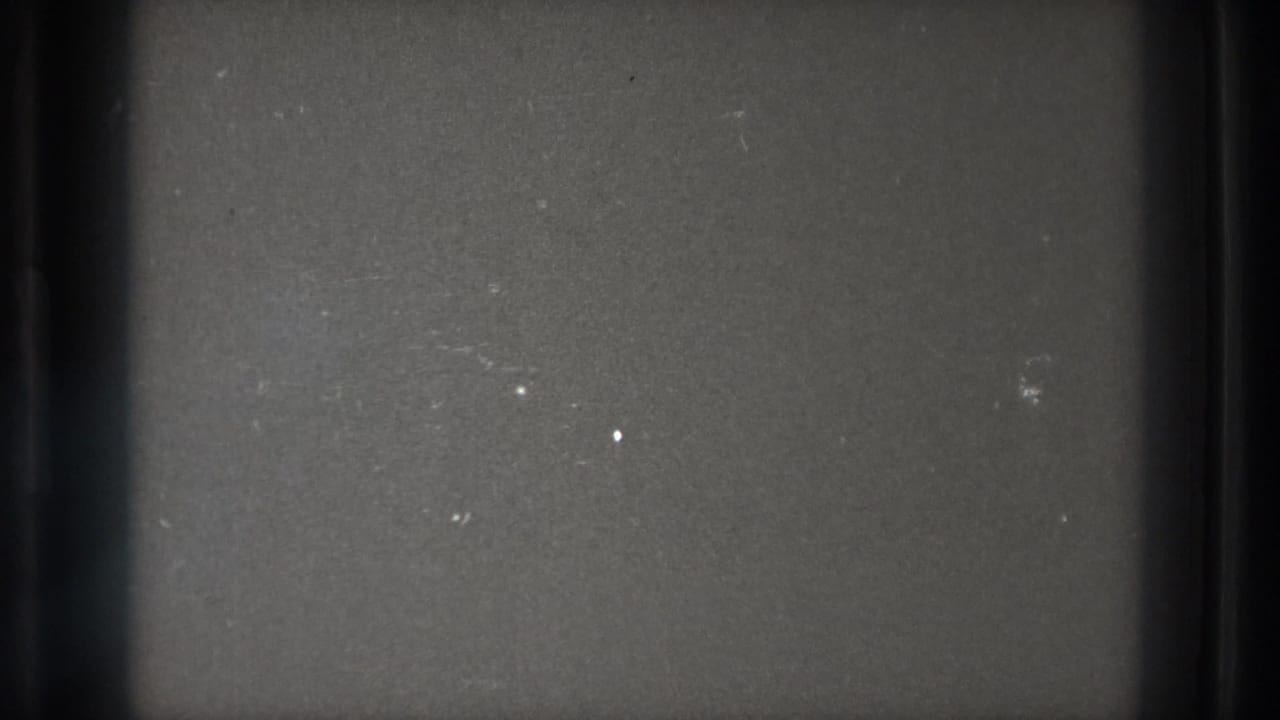 Gray 8mm leader frame from the 1971 Tokyo reel, showing dust, scratches, soft exposure, and dark gate edges.