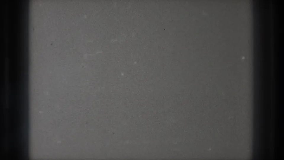 1971 Tokyo 8mm frame showing a soft grey television static field divided by dark vertical bands and visible film grain.