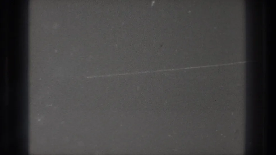 Cataloged Tokyo 1971 8mm frame with a mostly dark, grainy field, black gate edges, and faint surface marks.