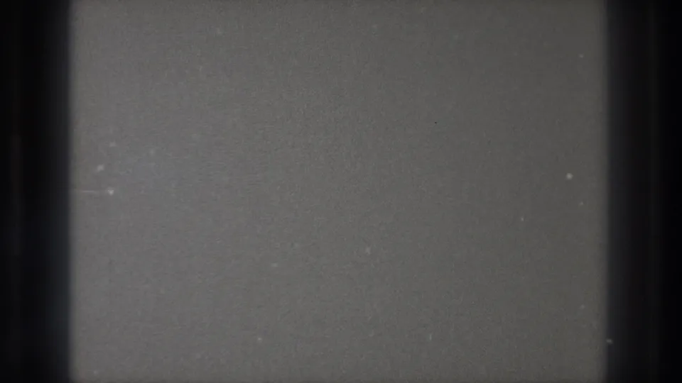 Blank 8mm frame from a Tokyo Japan 1971 source, showing gray film texture, dark edge bands, dust, and faint scratches.