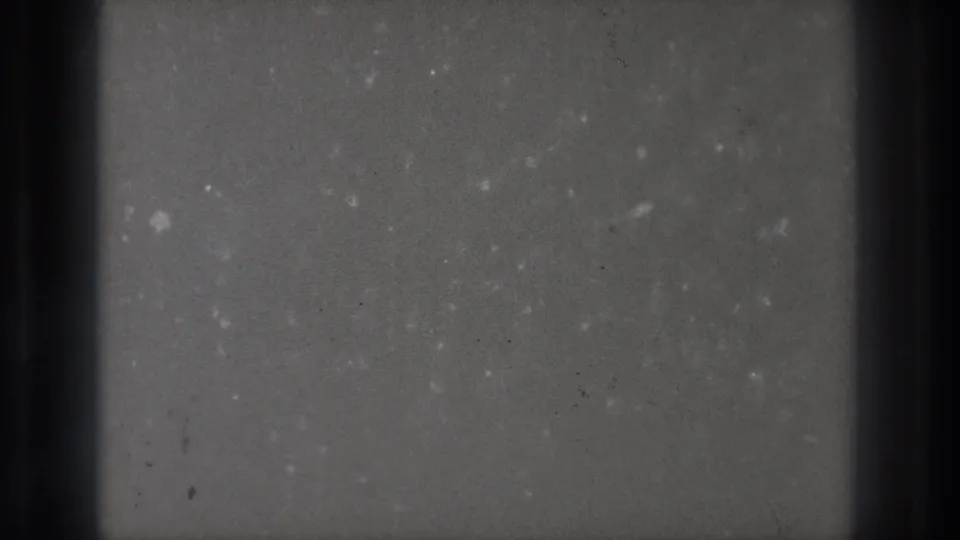 Small-gauge 1971 Tokyo home-movie footage appears as gray film fields, dark projector bands, dust, and surface marks.