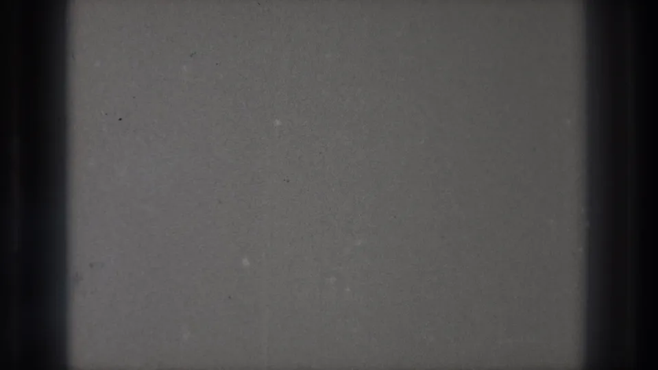 1971 Tokyo 8mm home-movie material showing projected film surface, dark edge bands, dust specks, grain, and minor scratches.