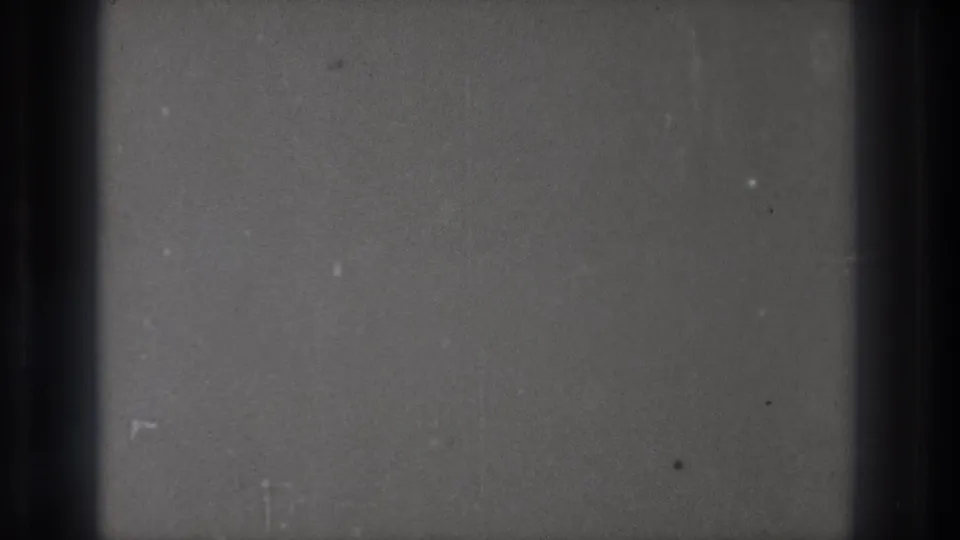Gray blank 8mm film from the 1971 Tokyo clip, marked by dust, faint scratches, and a dark vertical frame division.