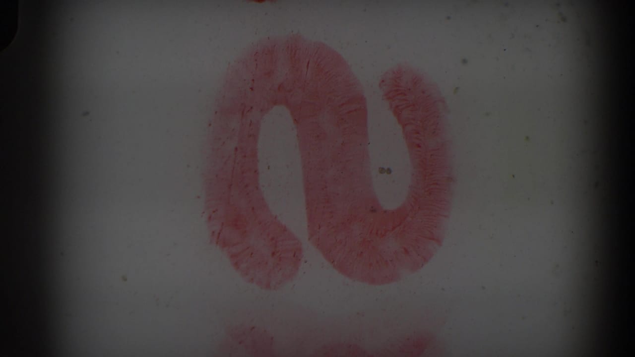 Red painted curved mark on a white surface with dark 8mm frame edges.