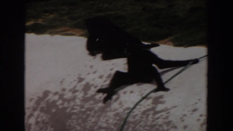 The final 1974 Irvine frame is darker, showing a primate form near grass and pale enclosure ground within strong film borders.