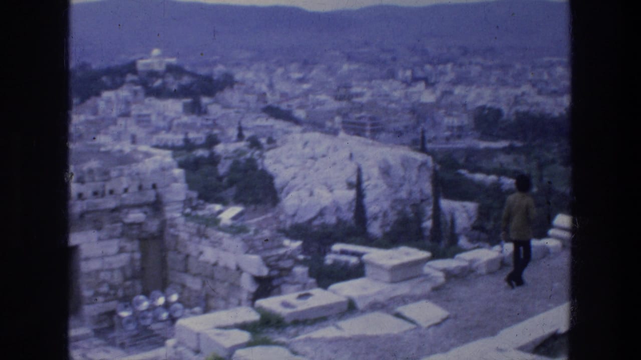 Adult visitor standing on stone ruins above a dense cityscape.