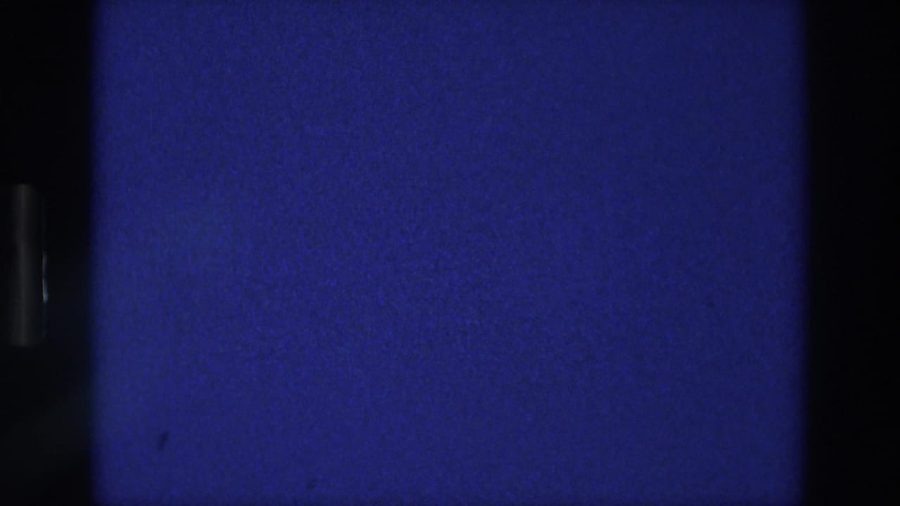 Blue film frame divided by dark vertical bars with grain and soft flicker.