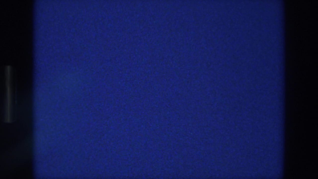 Blue sky field with fine grain, slight haze, and black vertical scan borders.