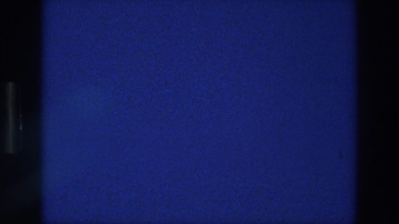 Deep blue film frame with black vertical edge and visible grain.