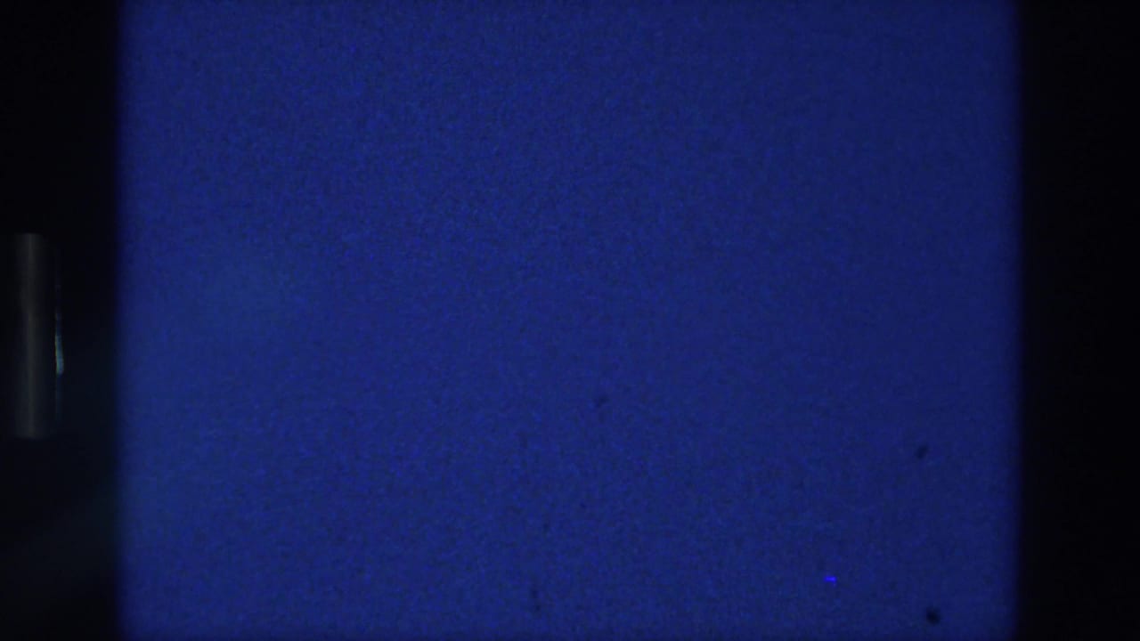 Blue static-like film frame with a central dark vertical band.