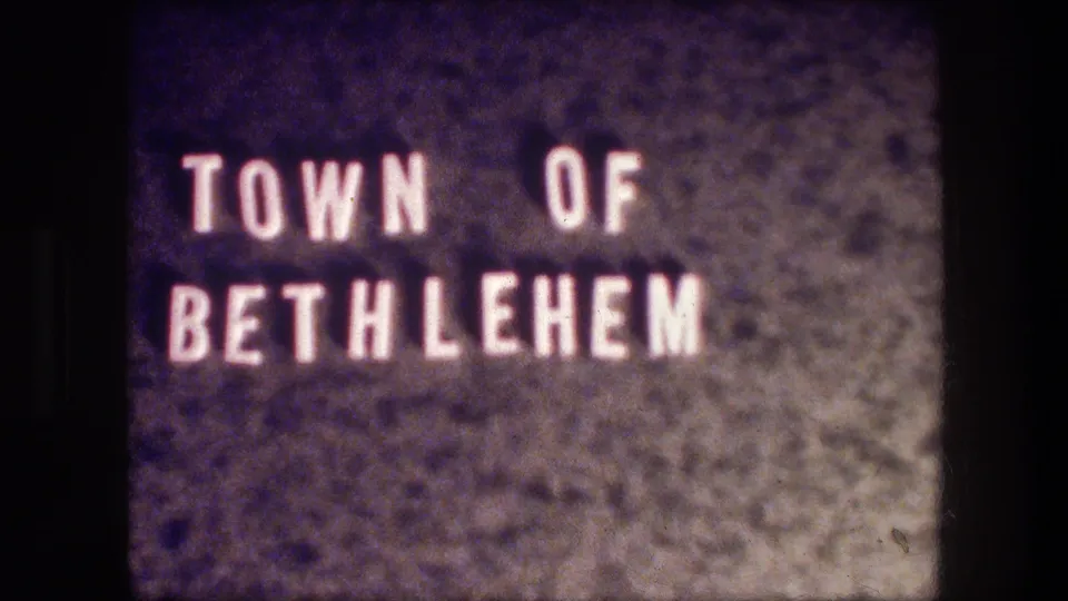 Soft 8mm frame showing the Town of Bethlehem title card against a dark, purple-tinged textured background.