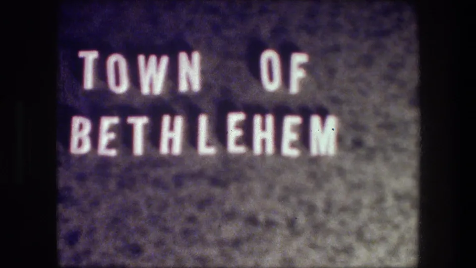 Soft 8mm frame showing the Town of Bethlehem title card, with white block letters and visible film texture.