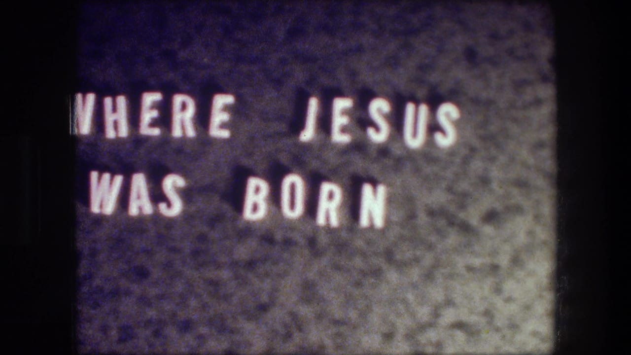 Close view of a filmed title card reading 'WHERE JESUS WAS BORN' in the 1976 Bethlehem travel clip.
