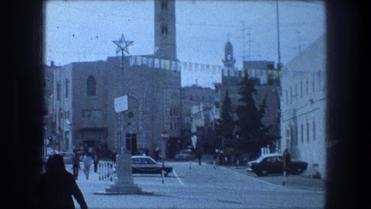 Wide street scene with pedestrians, parked and moving cars, tower, banners, and star symbol.