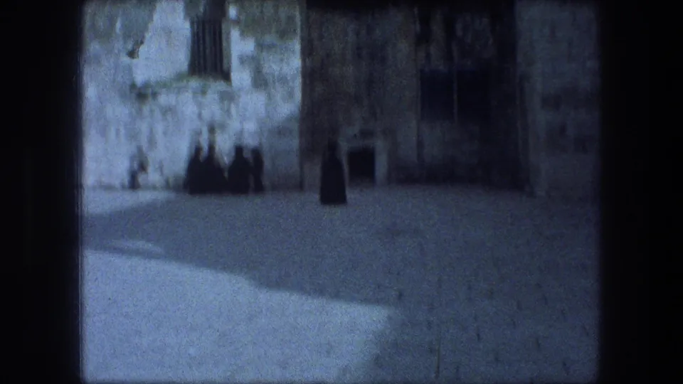 Soft 8mm view in Bethlehem showing stone architecture, a shaded doorway or arch, and distant figures near the wall.