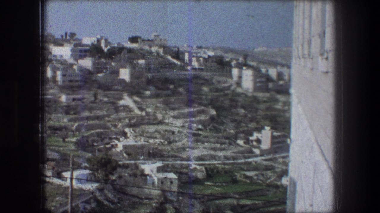 1976 8mm frame identified as Bethlehem, showing a high-angle view over pale buildings and terraced hillside roads.