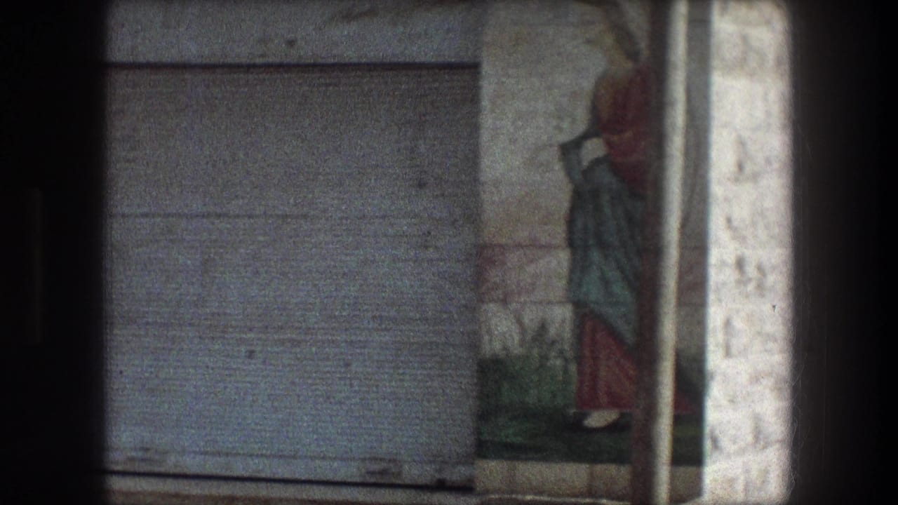 Painted figure on a stone wall beside a closed metal door.