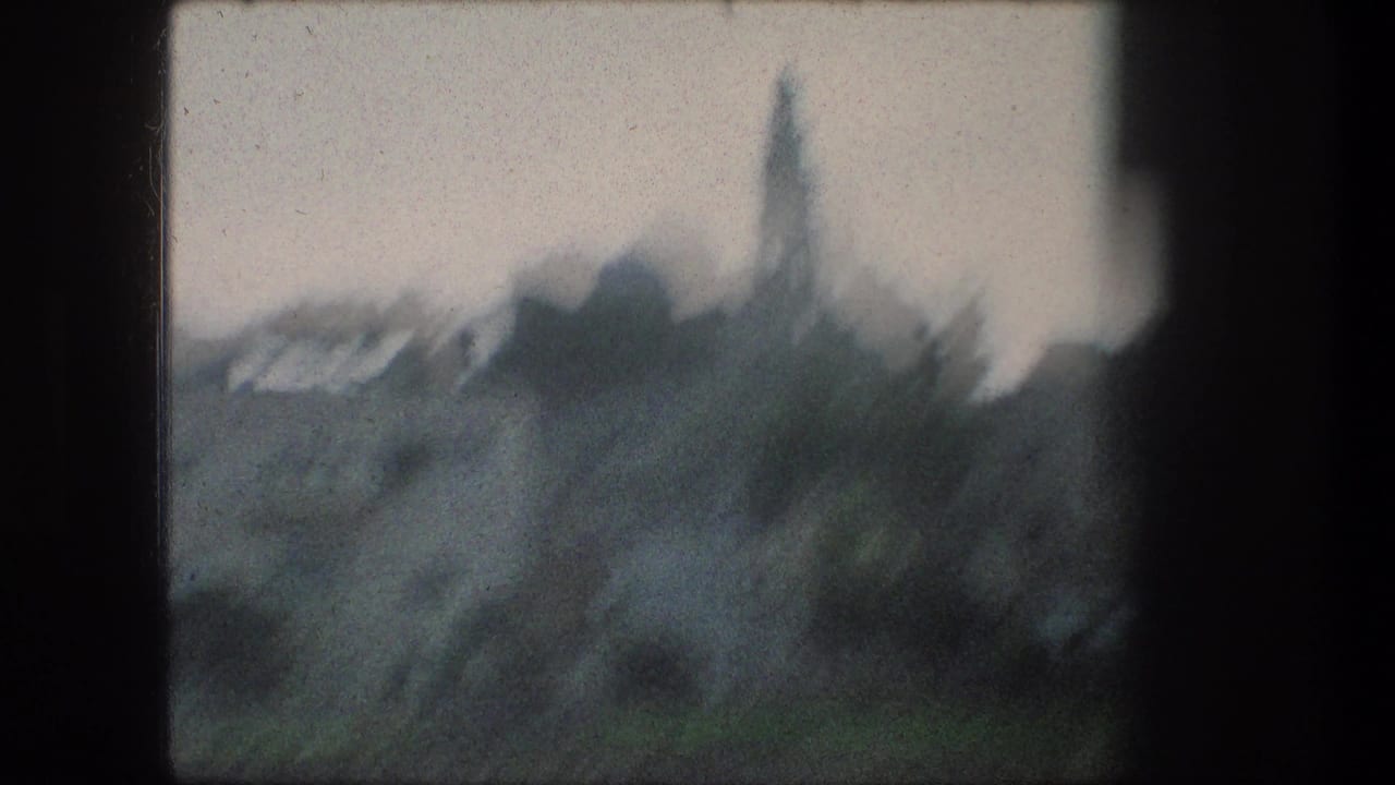 Hazy town skyline seen through a dark window frame.